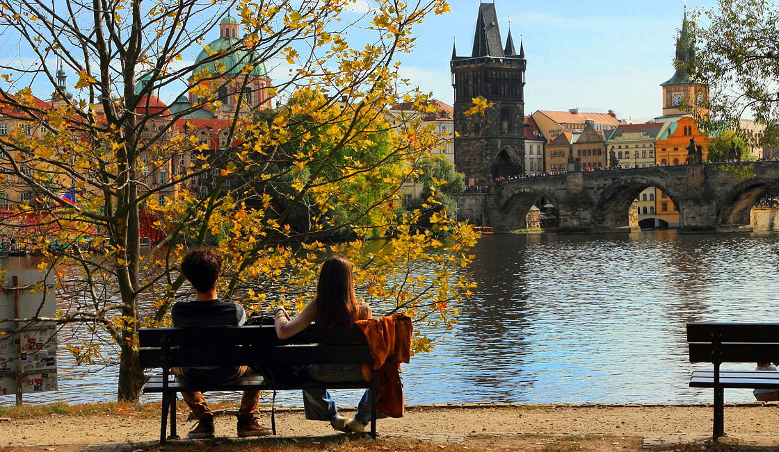 Czech Rep, PRAGUE, River Vlatava, and two people on riverside bench, CZ1508JPL A 1120