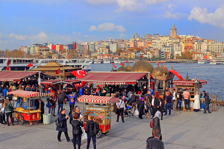 TURKEY, Istanbul, Eminonu Waterfront, food stalls and crowds, New City in background, TUR969JPL A 770