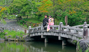 Japan, KYOTO, Maruyama Park, pond and stone bridge, courting couple, JPN952JPL 300