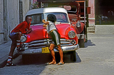 CUBA, Havana, old town, couple chatting beside an old American car, CUB284JPL 370