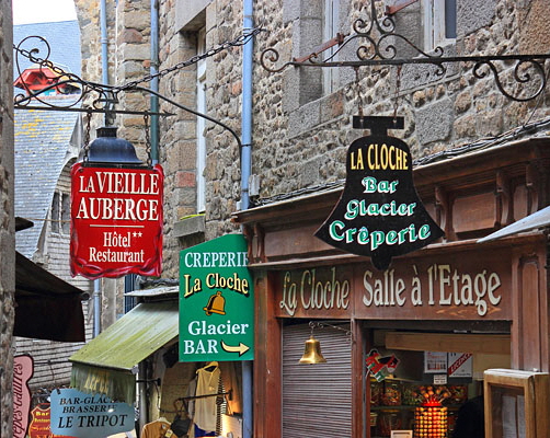 FRANCE, Normandy, MONT SAINT-MICHEL, narrow streets, hotel & restaurant signs, FRA2791JPL A 600