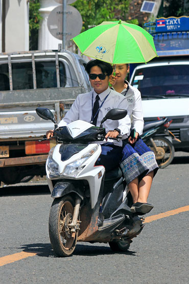 LAOS, Luang Prabang, couple on bike with brolly to shade from the sun, LAO741JPL 370