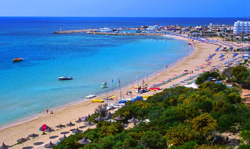 CYPRUS, Aiya Napa, beach with sunshades, and harbour in background, CYP493JPL A 800