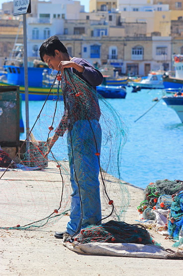 MALTA, Marsaxlokk, fishing village, fisherman sorting out fishing nets, MLT1039JPL 370
