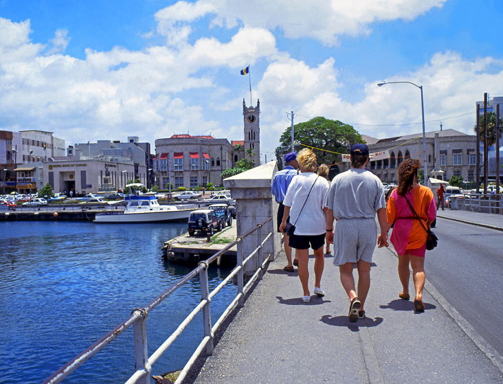 BARBADOS, Bridgetown, tourists on Chamberlain Bridge and tourists, government bruildings & clocktower, BAR508JPL A 750